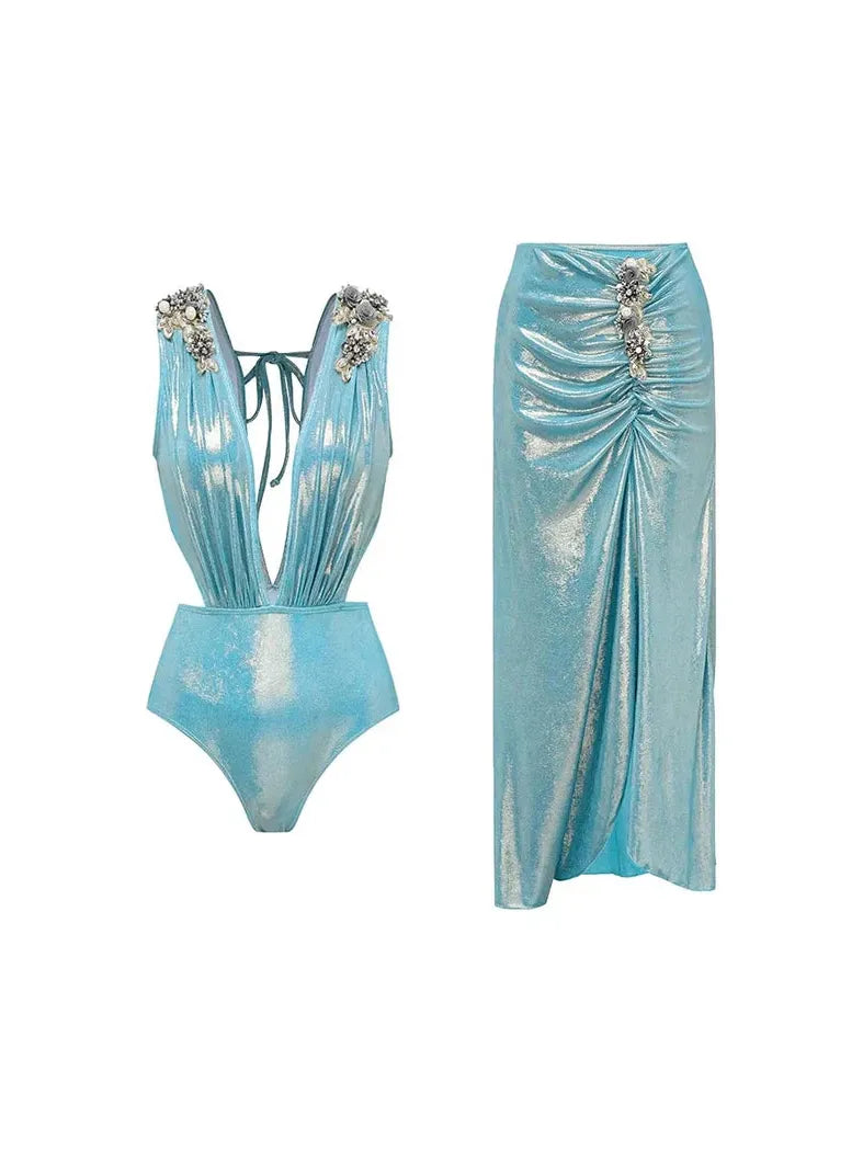 Aqua metallic swimsuit with deep V-neck and crystal floral shoulder accents, plus a shimmering ruched skirt.