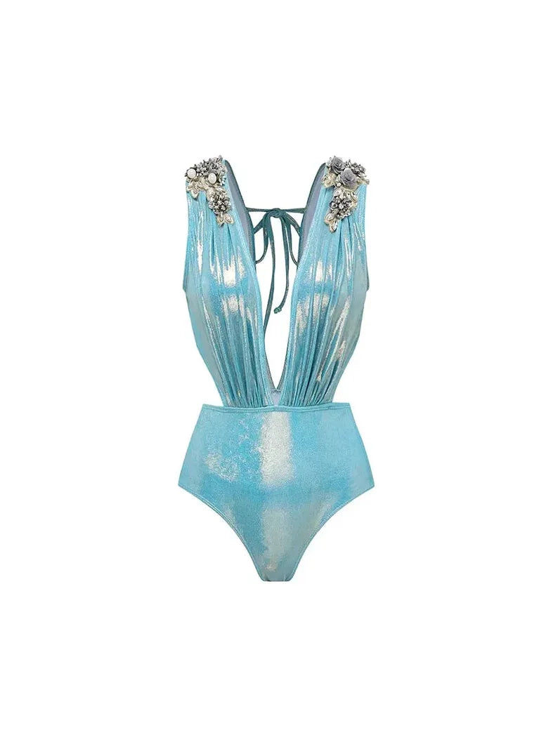 Shimmery aqua one-piece with plunging V-neck, halter tie-back, attached skirt, and floral shoulder embellishments.