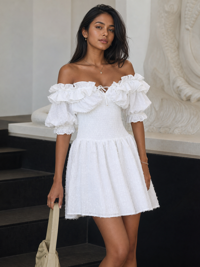 Ruffled off-shoulder white short dress with elastic waist and puff sleeves, shown on model.
