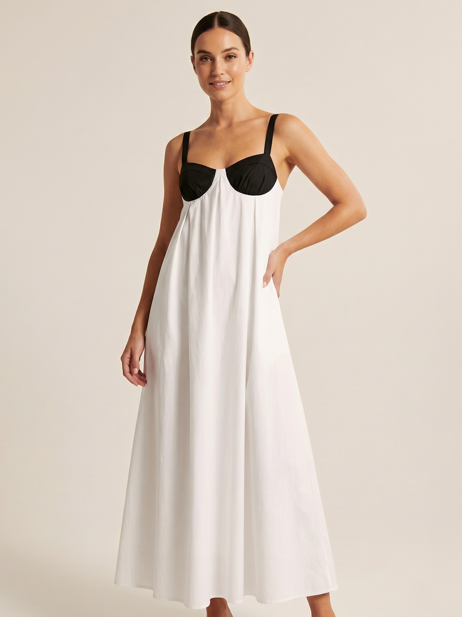 Model wearing a white maxi slip dress with black colorblock bust, thin black straps, and a flowing A-line skirt.