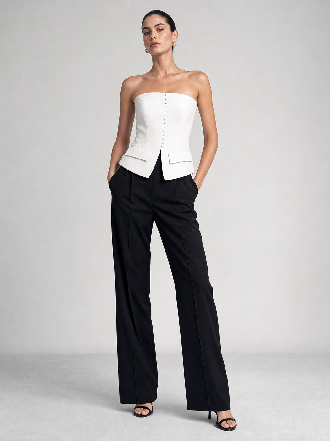 Button-up Vest Tube Top by EXCLUSIVES; white strapless peplum top with center buttons, paired with black trousers.