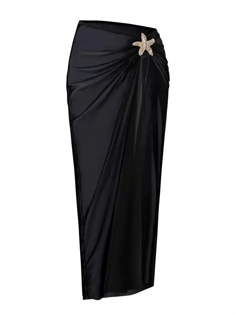 Black sarong-style wrap skirt with ruched drape and rhinestone-studded starfish ornament at the waist.