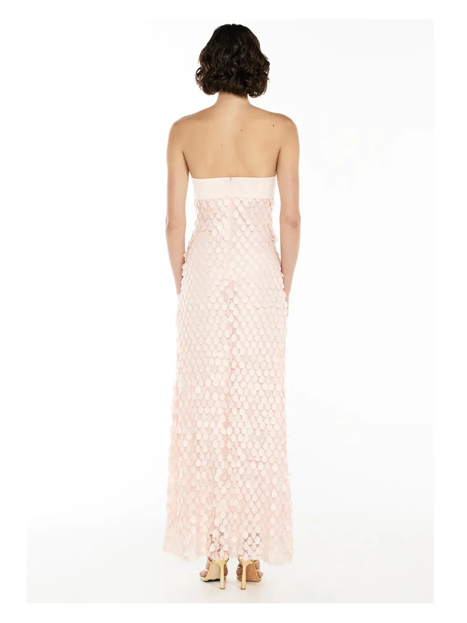 Back view of pale pink mermaid sequin strapless maxi dress with a cream band at the top, floor-length disk sequins.