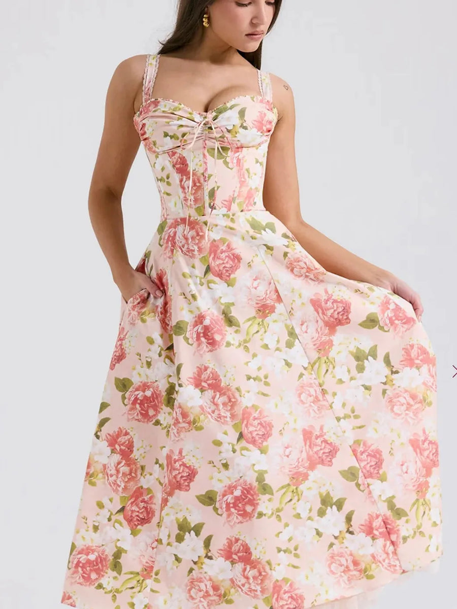 Pink floral corset midi dress with sweetheart neckline, ruched front, wide straps, pockets, and a full A-line skirt.
