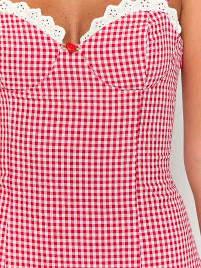 Gingham red-and-white short dress with white lace neckline trim, a small red rose at center, and adjustable straps