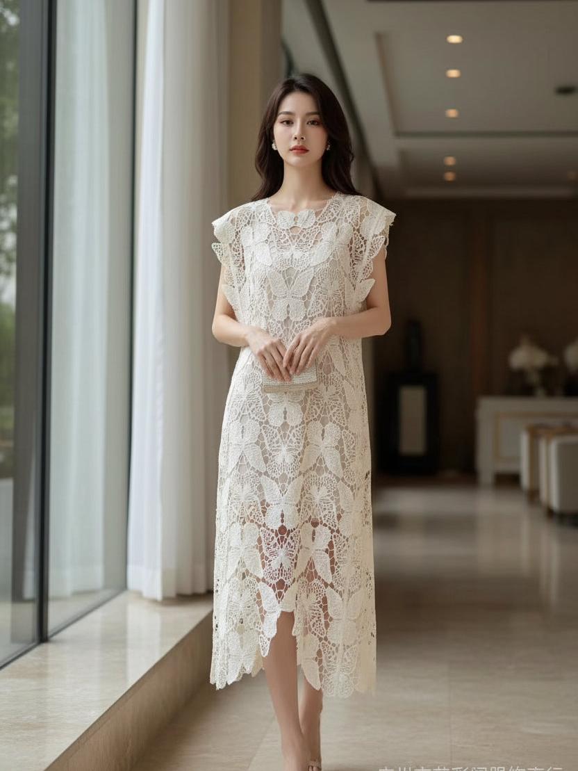 Woman in cream lace butterfly-cutout midi dress over jeans, holding a black lace dress on a hanger; braided hair.