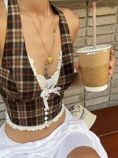 Deep halter-neck gingham top with white lace trim and front bow; woman holds an iced coffee beside a brick wall.