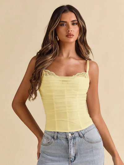 Pale yellow lace-trimmed ruched mesh corset cami top with spaghetti straps on a model.