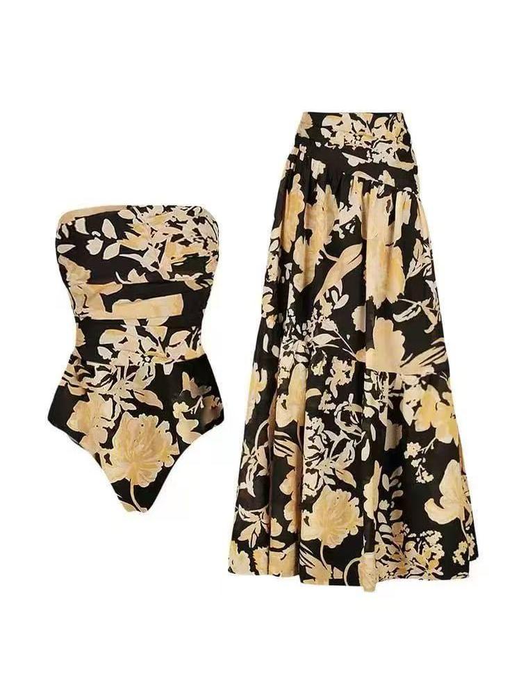 Strapless black floral tube swimsuit with beige blossoms and a long matching skirt.
