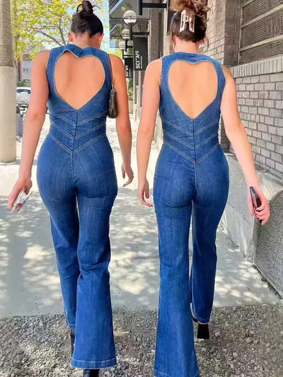 Two women in sleeveless blue denim flare jumpsuits with heart-shaped back cutouts, walking away on a city sidewalk.
