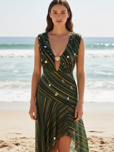 Calypso striped plunge monokini and asymmetric skirt set in green tones worn by a model at the beach