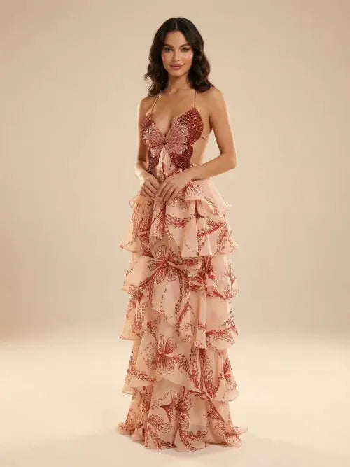 Model wearing blush-pink butterfly-print tiered-ruffle maxi dress with spaghetti straps and a waist-tie bow.