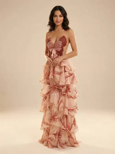 Model wearing blush-pink butterfly-print tiered-ruffle maxi dress with spaghetti straps and a waist-tie bow.