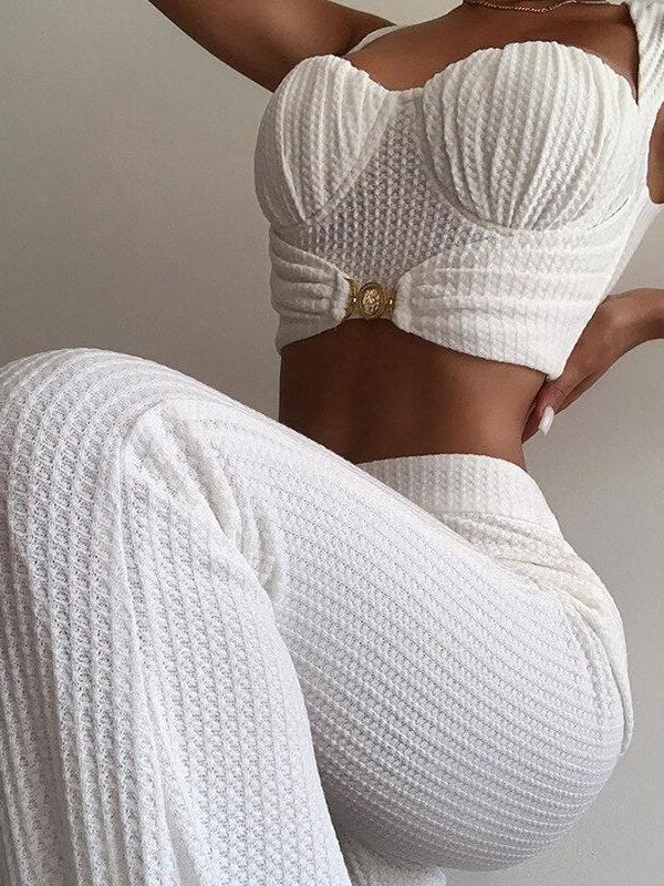 White textured ruched crop top with sweetheart bust and matching high-waisted knit pants, gold circular belt clasp.