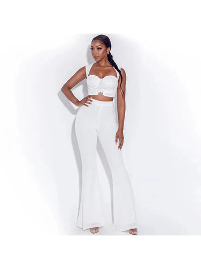 Model in a white ruched bustier-style crop top with thick straps and matching high-waisted wide-leg pants.
