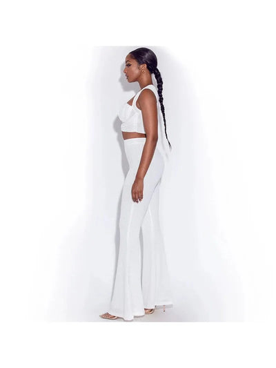 Side profile of a woman wearing a white ruched crop top and matching wide-leg pants coord set, with a long braided ponytail.