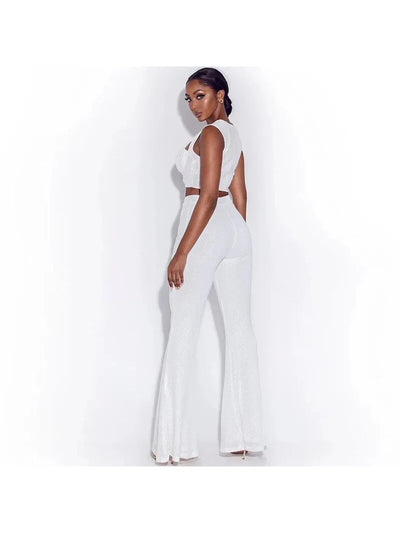 Profile view of a model in a white ruched crop top and matching high-waisted wide-leg pants, textured fabric.