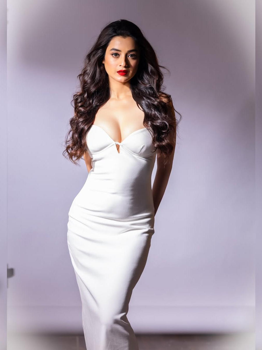 White satin sweetheart-neck midi dress with a small front cut-out, form-fitting silhouette on a model with dark hair.