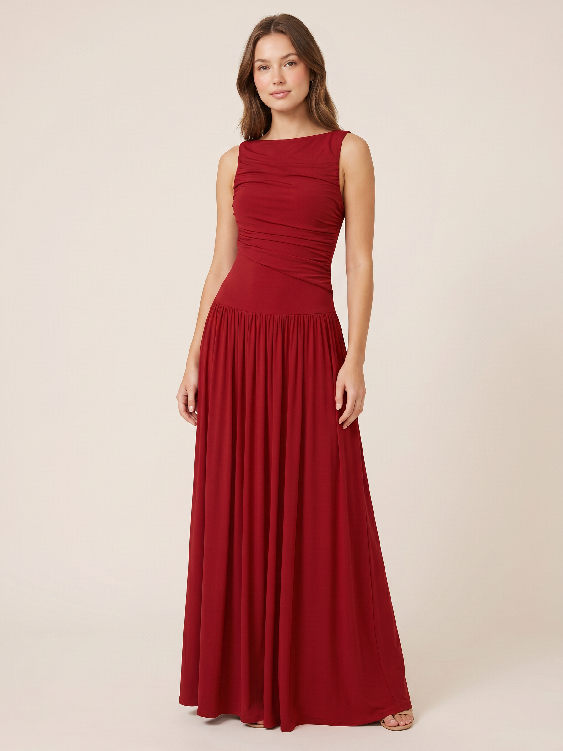 Sleeveless Ruched Maxi Dress in red worn by a model with a long flowing skirt