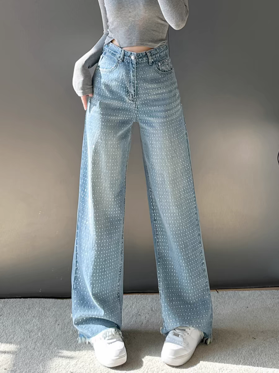 Light-blue wide-leg denim jeans dotted with rhinestones, high-waist, paired with a gray cropped top and white sneakers.
