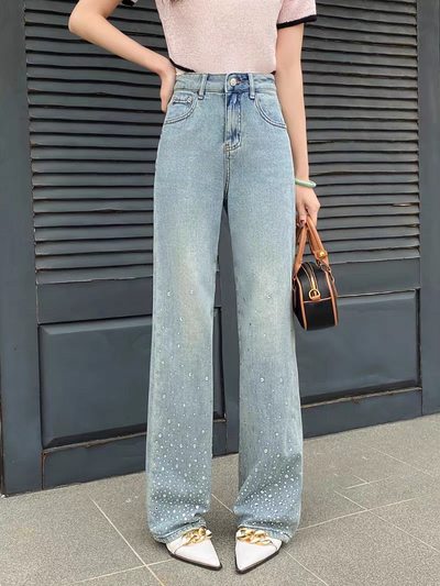 Light-wash blue wide-leg denim jeans with rhinestones at the bottom hem, worn with a pink top.