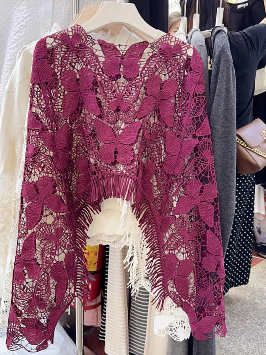 Magenta butterfly lace crochet top on hanger; hollow cutout design with butterfly motifs and tassel fringe at the hem.