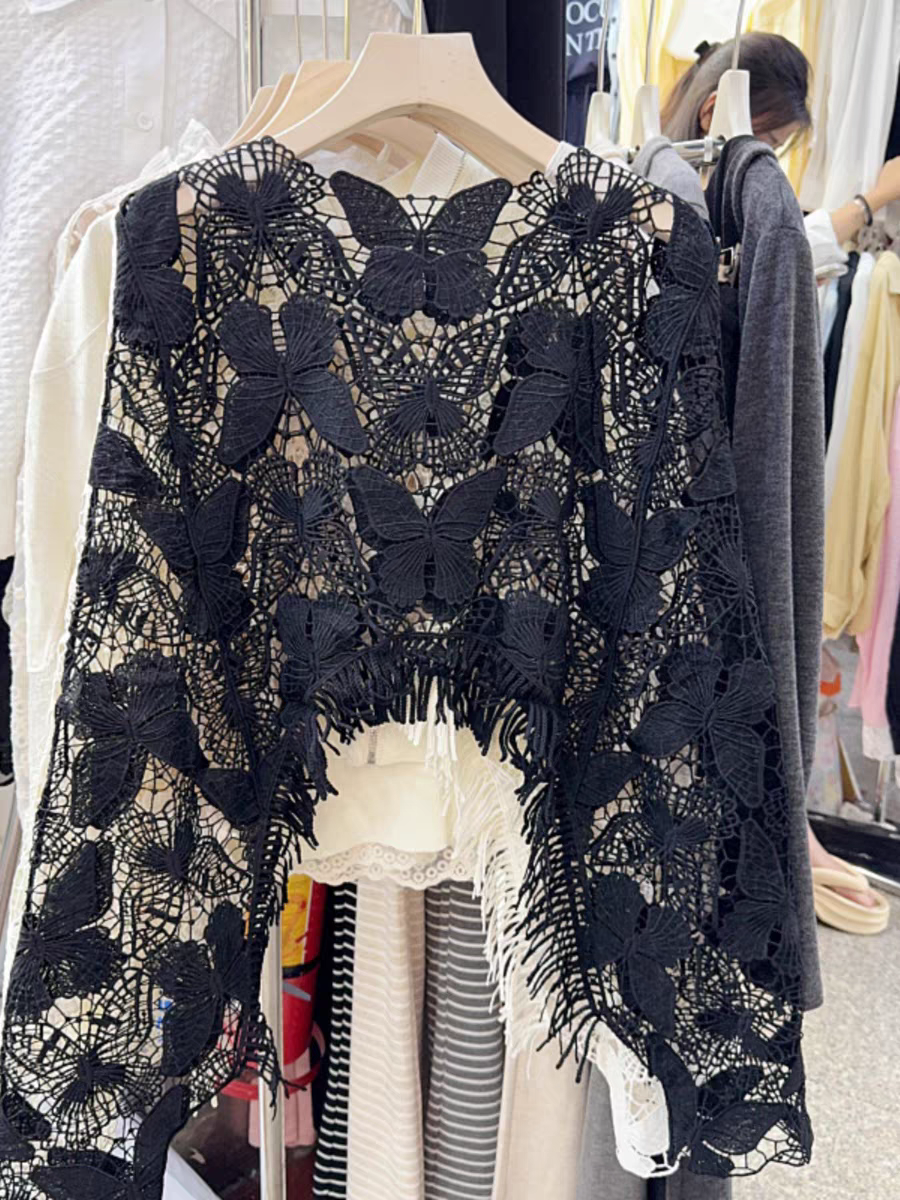 Black crochet lace top featuring butterfly motifs, hollow cutouts, and fringe tassel hem.