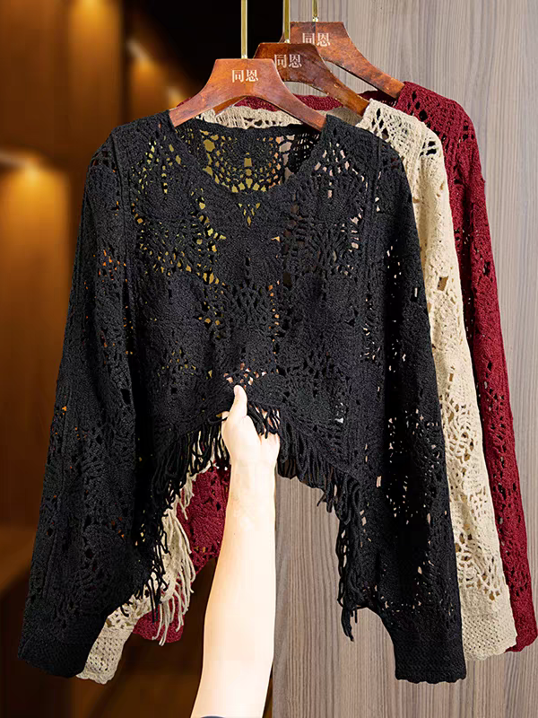 Black butterfly-cutout tassel crochet top with fringe hem, on a wooden hanger; cream and burgundy versions visible.