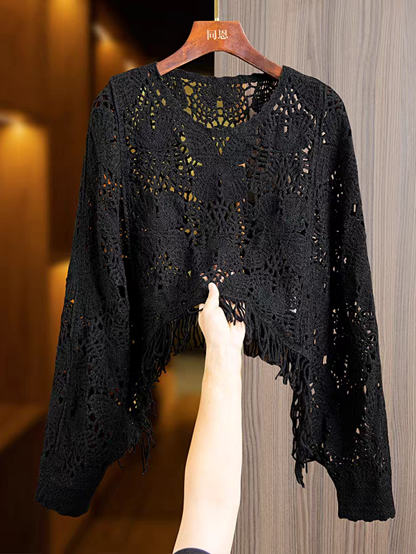 Black crochet hollow-cut butterfly lace top with fringed tassel hem on a hanger; long sleeves, sheer floral lattice.