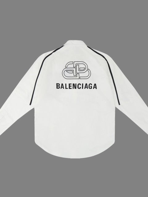 White oversized shirt back view with black piping along shoulders; Balenciaga logo and emblem on the back.