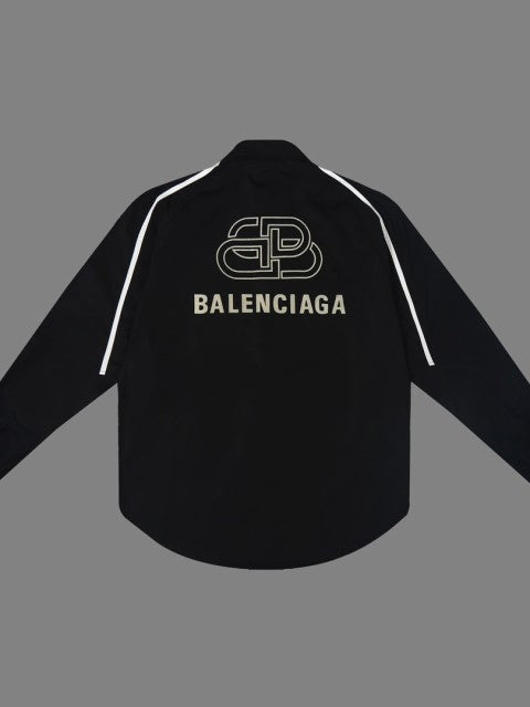 Black oversized shirt viewed from back with white shoulder piping and beige Balenciaga logo.