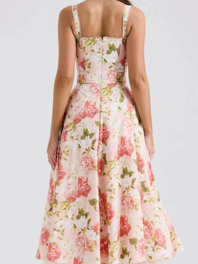 Back view of a floral corset midi dress with wide straps, fitted waist, center seam, and a rose-print A-line skirt.