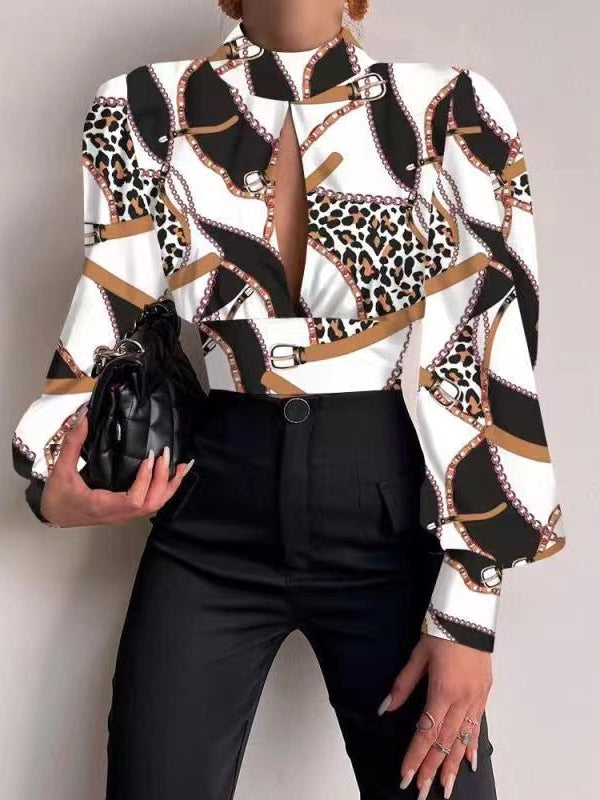 White satin crop top with leopard and chain print, keyhole neckline, sleeves, black pants, quilted clutch.