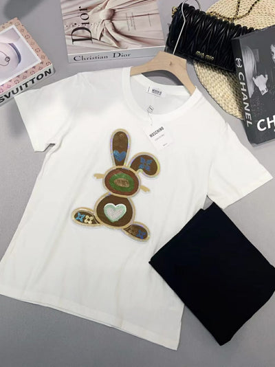 White cotton Lycra T-shirt laid flat with large sequined bunny applique on the front; tag visible.