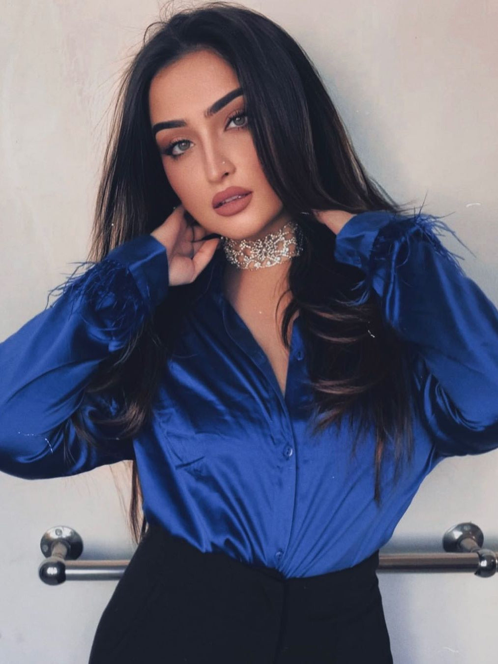 Cobalt blue satin shirt with feathered fur sleeves, black bottoms, and a rhinestone choker.