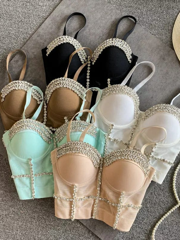 Assorted diamond-studded push-up bralettes in black, nude, white, mint, and peach with crystal trim along cup edges and vertical seams.