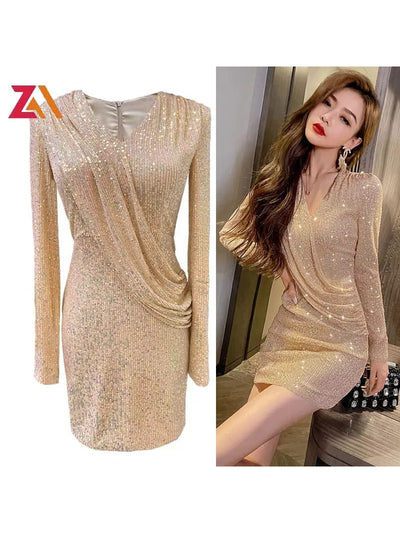 Champagne-gold sequin dress with long sleeves, wrap-draped waist and V-neck, knee-length with allover sparkle.