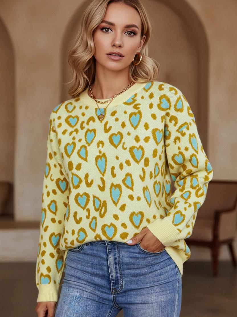 Yellow knit crew-neck sweater with blue heart shapes and brown spots, worn with blue jeans.