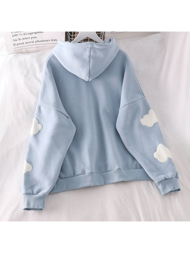 Light blue oversized hoodie seen from the back with white fluffy cloud patches on both sleeves, hood up.