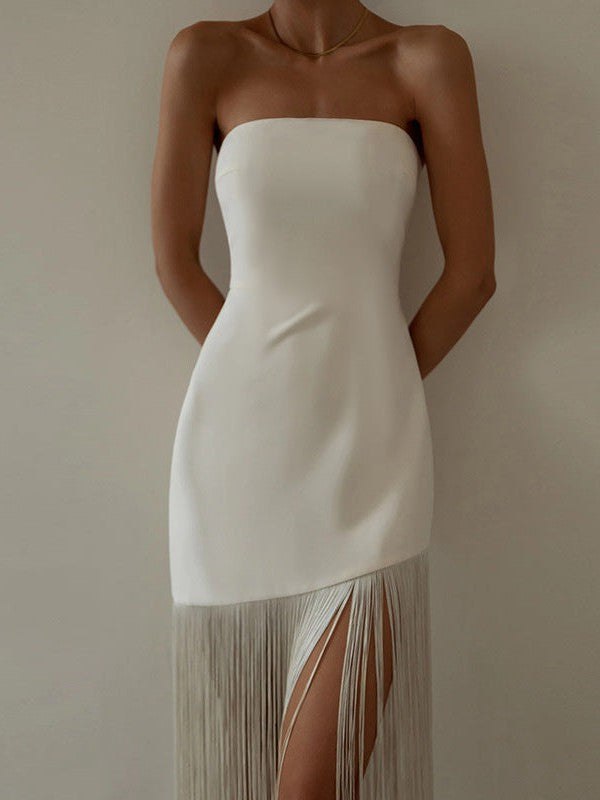 White strapless tube dress with a fringe tassel hem and a thigh-high front-left slit.
