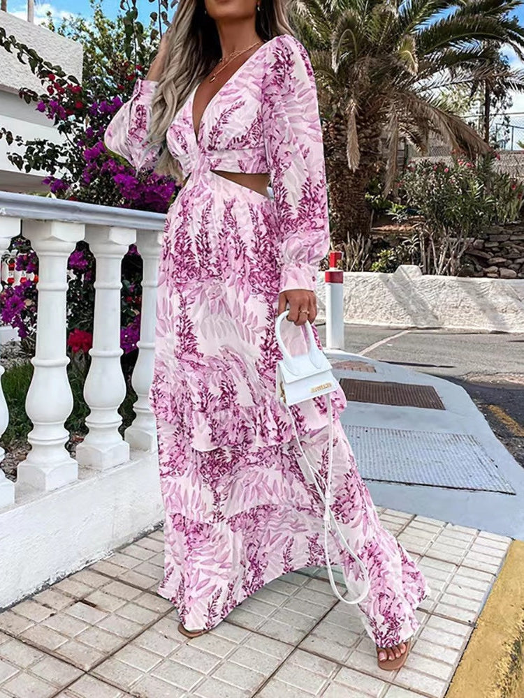 Pink and white floral cutout maxi dress with long sleeves, V-neck, waist cutout, tiered ruffled skirt, worn outdoors.